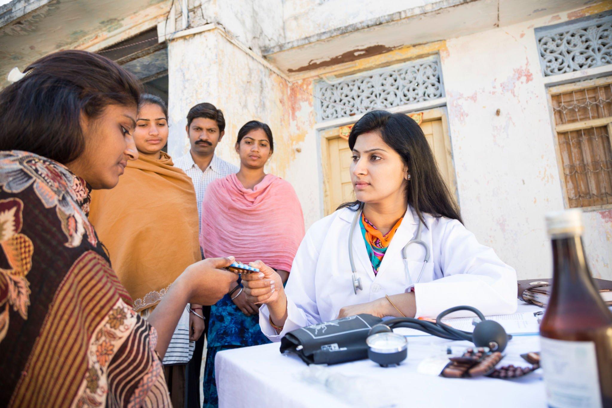 A female doctor treating people of a village